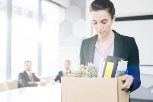 Woman carrying box of personal items after quitting her job | Counseling for Life Transitions including empty nest syndrome, retirement and college graduation | Houston Therapist 77006
